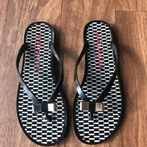 Black & White Coach rubber flip flops w/ gold bow